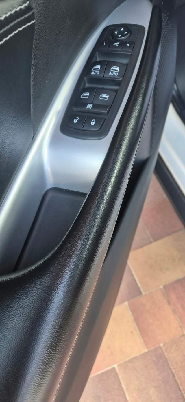Panel drzwi samochodu z przyciskami sterowania szybami.