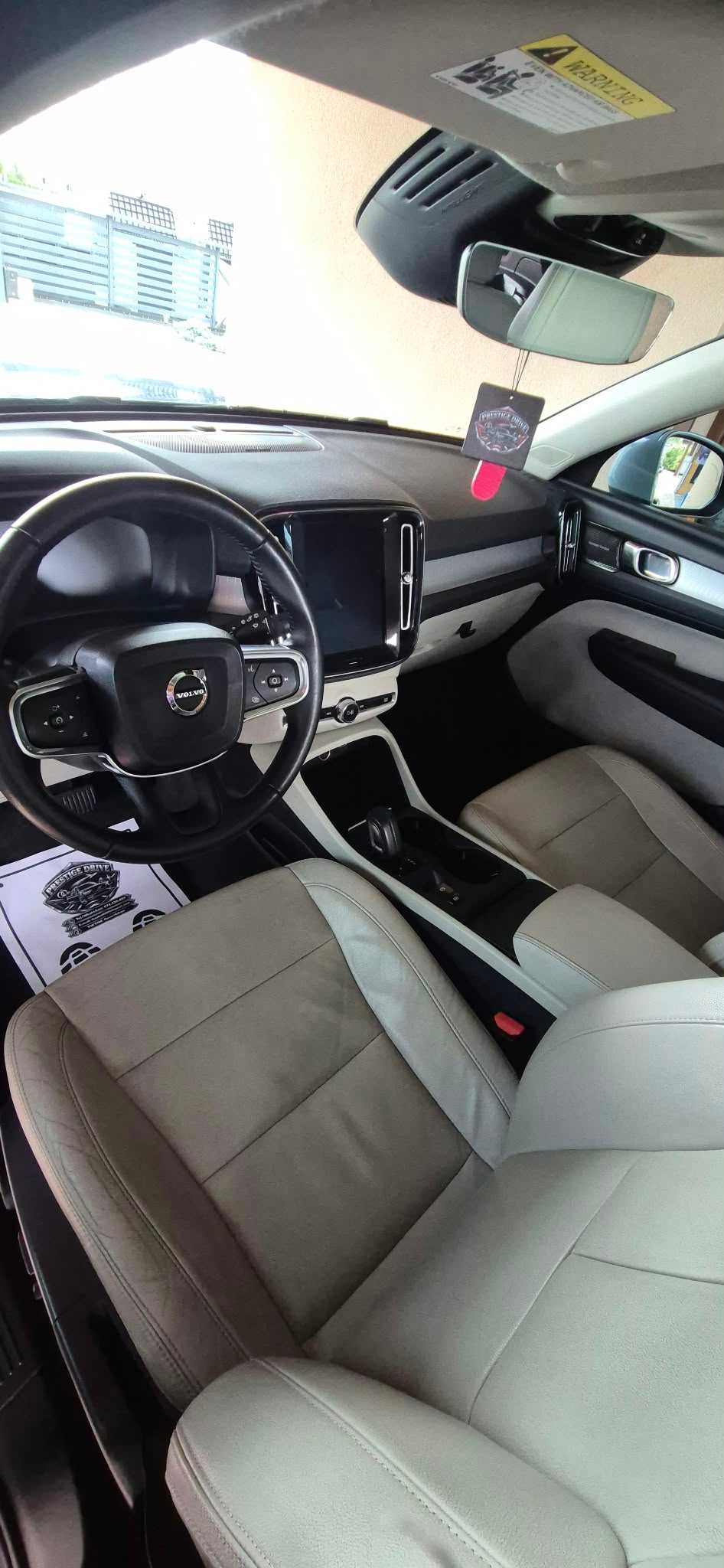 Jasne przednie fotele, kokpit i konsola Volvo.